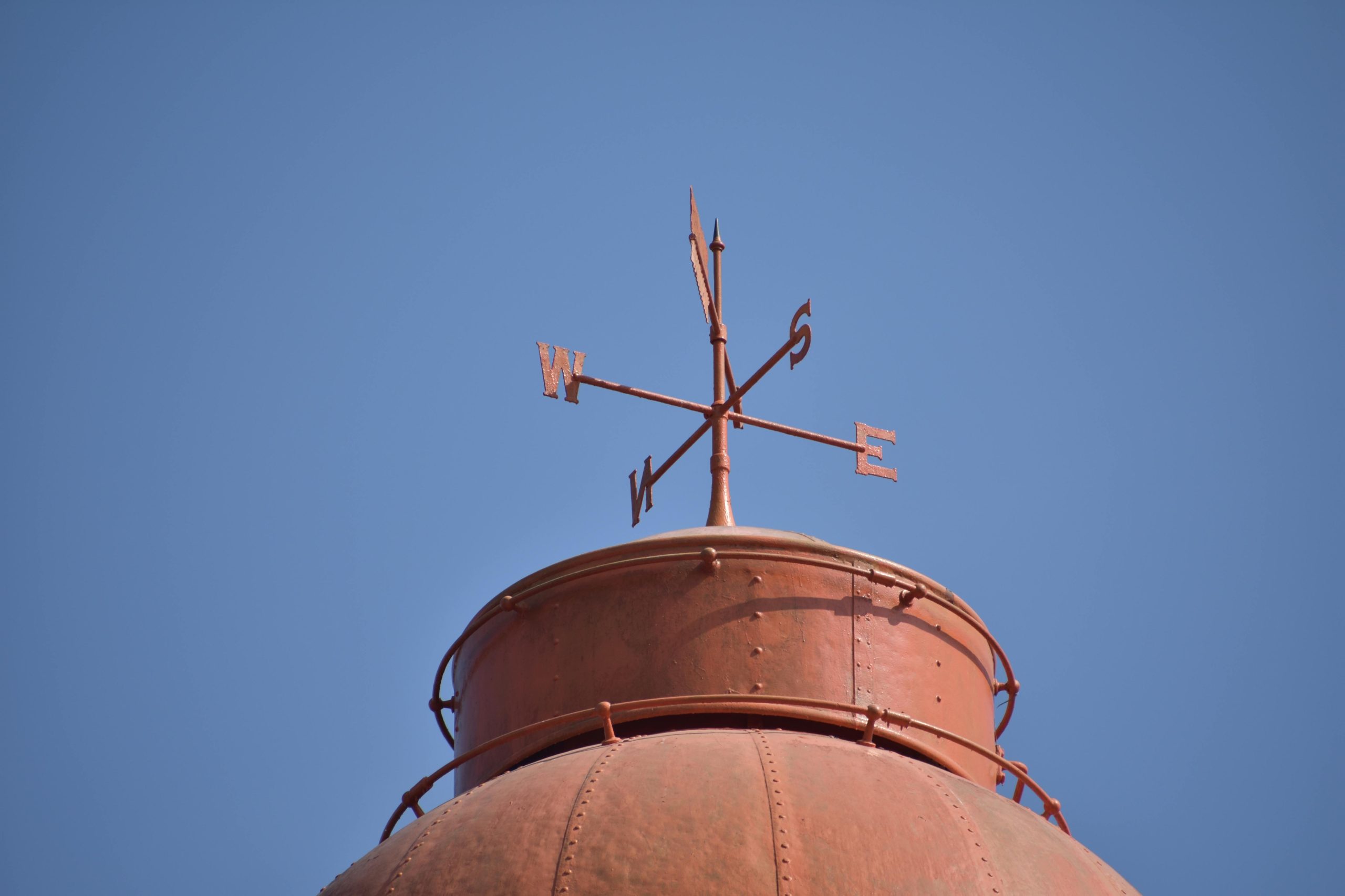 Weather vane silhouetted against the sky, symbolizing the ability to sense changes in direction before they become visible — a metaphor for detecting early signals in crisis management.