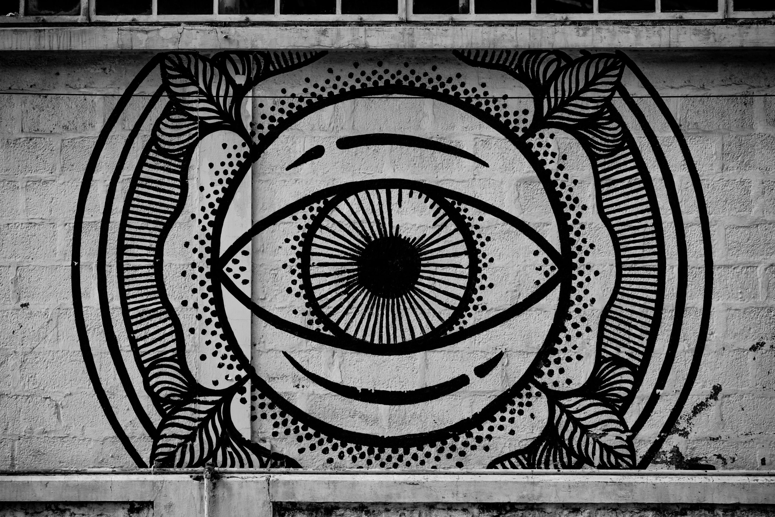 The Intelligent Eye Black-and-white mural of an abstract eye, symbolizing Coram’s AI-enabled video analytics and ability to see hidden risks in real time.